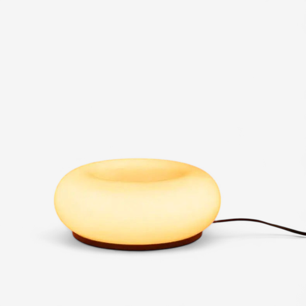 Donut table lamp with warm ambient glow on white background