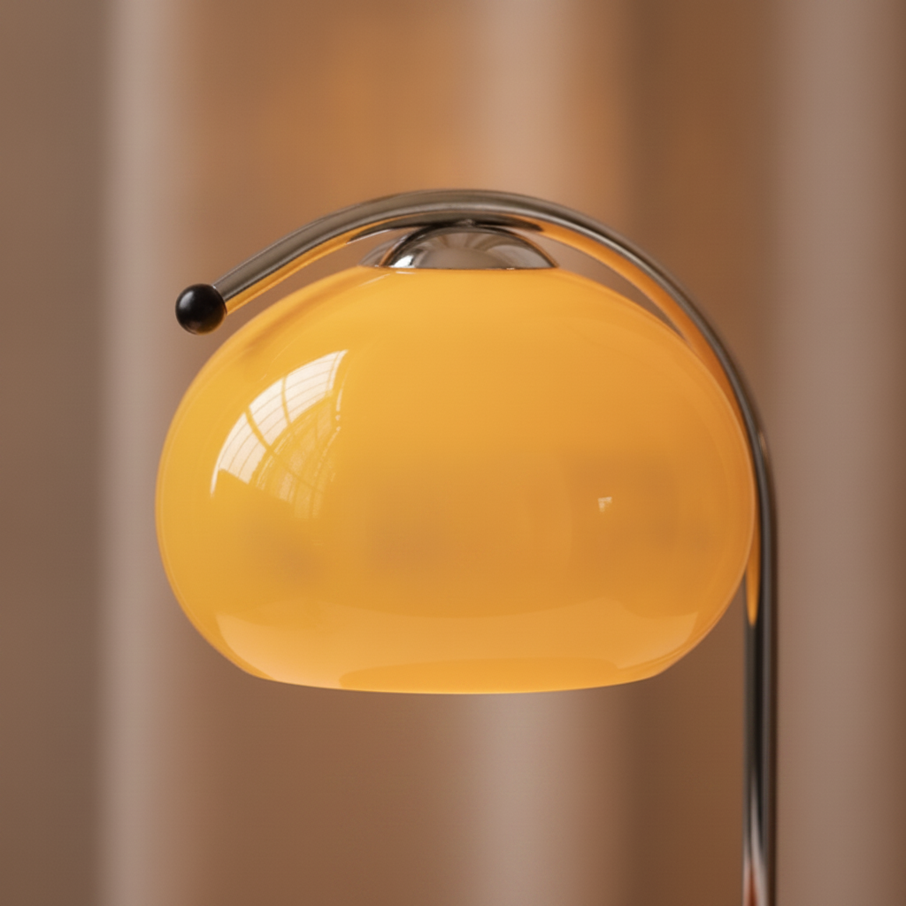 Close-up detail of glowing glass globe and chrome arm on candle warmer lamp